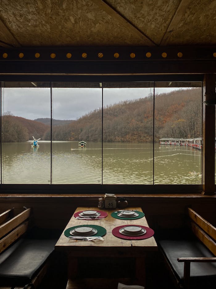 A table with a view of a lake and a boat